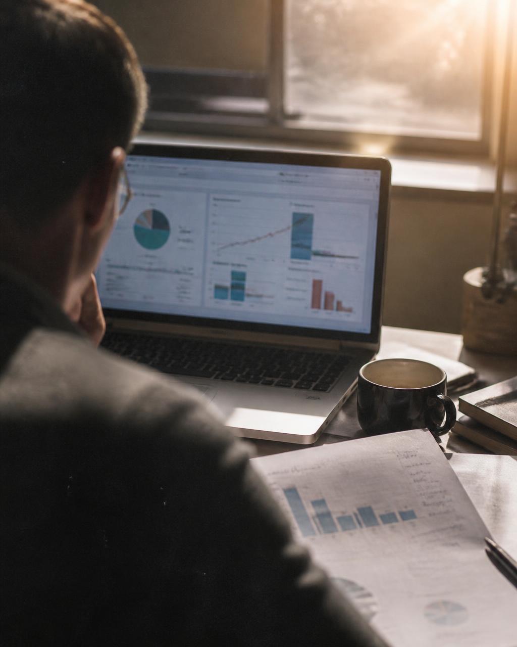 Revenue and conversion analytics dashboard beside a printed quarterly business review
